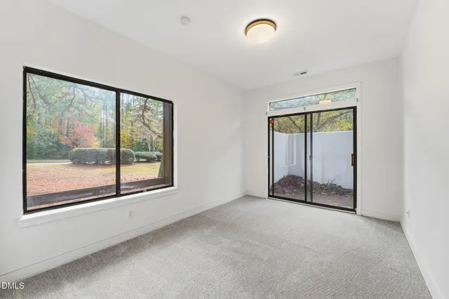 an empty room with sliding glass door and windows