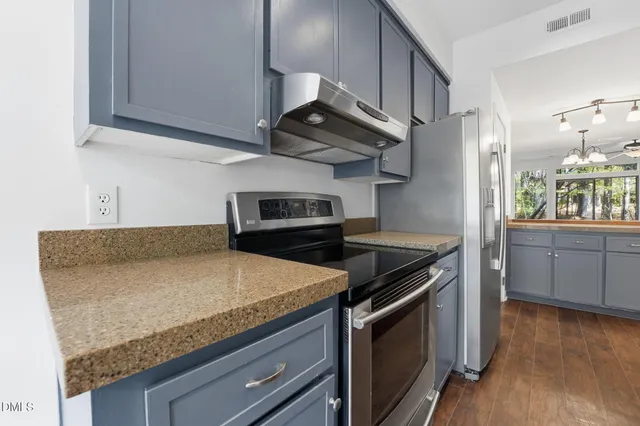 a kitchen with stainless steel appliances granite countertop a stove and a microwave