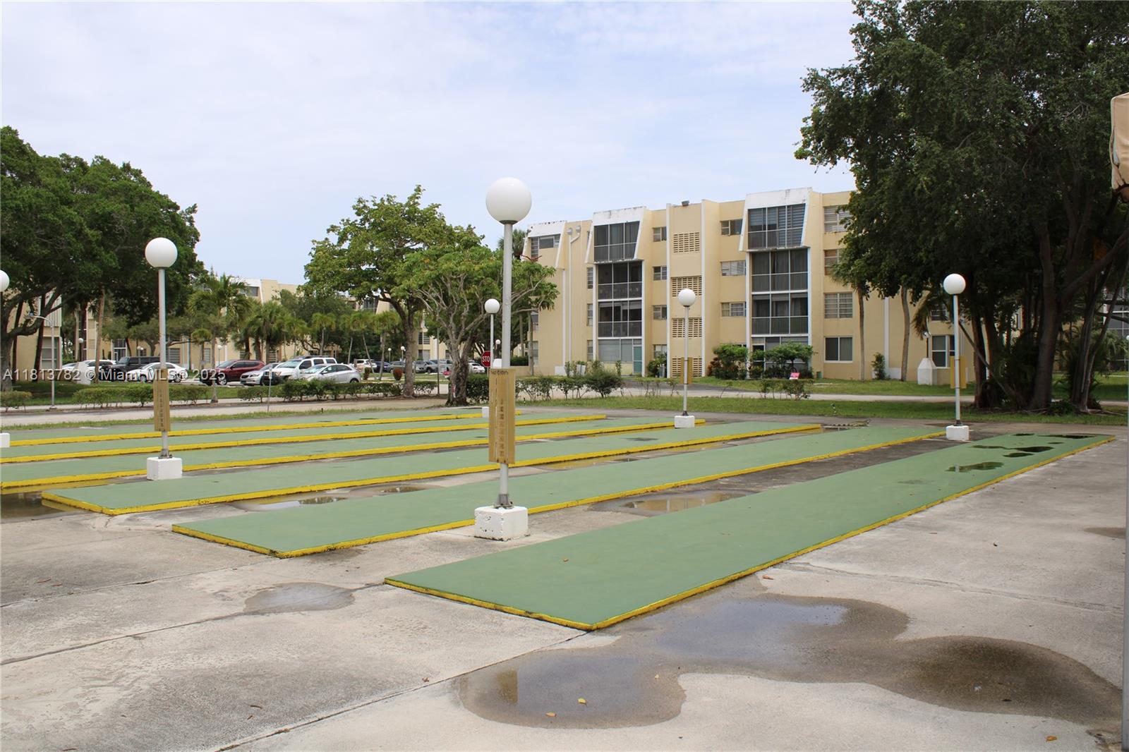 922 Northeast 199th Street, Unit 3D 304 Miami, FL 33179 - Photo 5 of 7 a view of a big building with trees and a big yard
