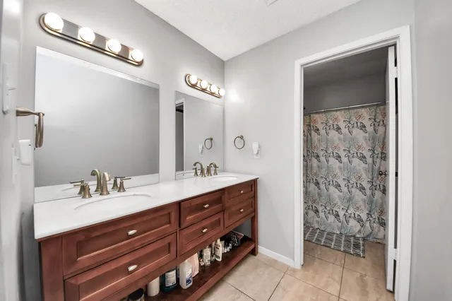 a bathroom with a double vanity sink mirror and shower