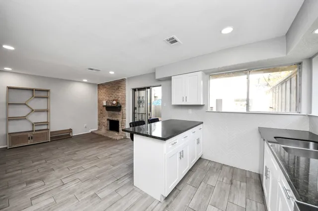 a kitchen with granite countertop a sink and a stove top oven