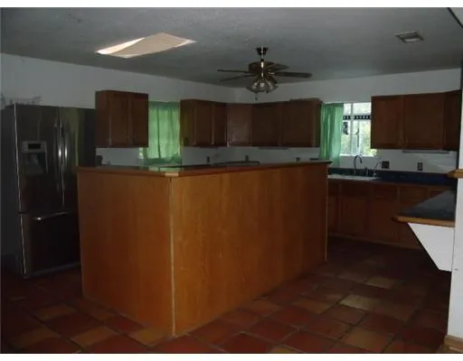a kitchen with kitchen island stainless steel appliances a sink cabinets and a counter top space