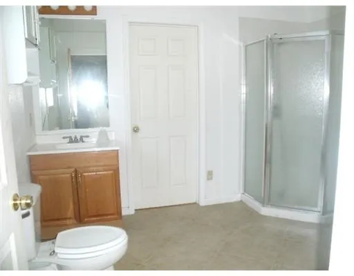a bathroom with a toilet a sink a vanity and mirror