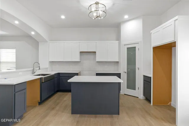 a kitchen with stainless steel appliances granite countertop a sink a stove a refrigerator and island with wooden floor