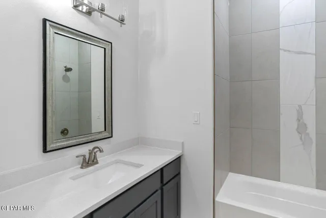 a bathroom with a sink vanity tub and shower
