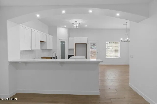 a large kitchen with granite countertop a large counter top a sink stainless steel appliances and cabinets