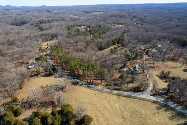 an aerial view of house with yard and mountain in the background