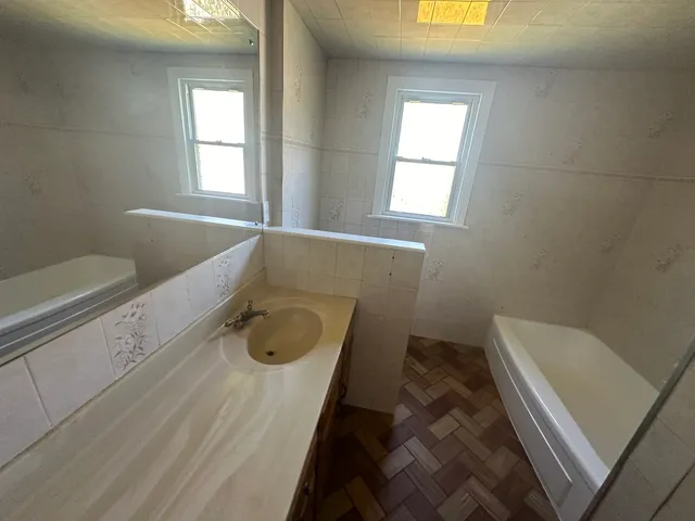 a bathroom with a granite countertop sink a toilet and bathtub
