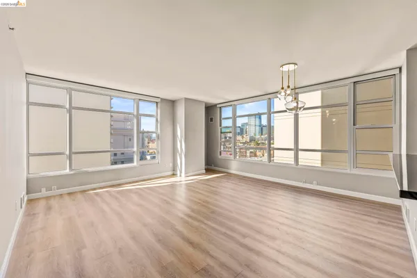 a view of a room with wooden floor and a ceiling fan