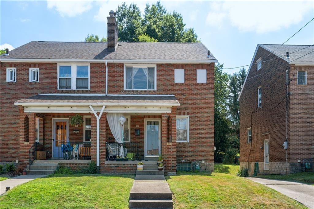 a front view of a house with yard and green space