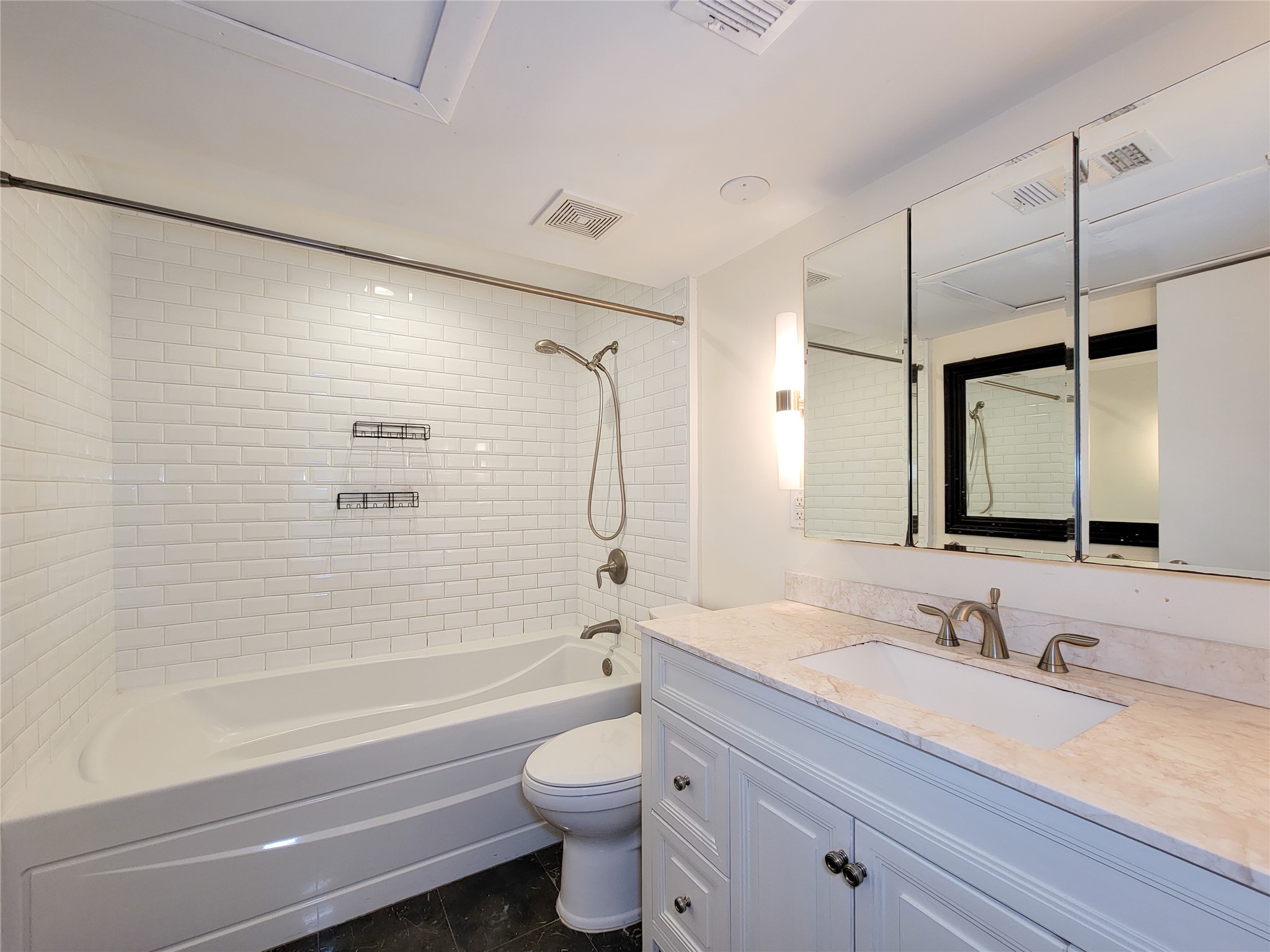 2243 West Alabama Street, Unit B Houston, TX 77098 - Photo 21 of 44 a bathroom with a granite countertop sink toilet vanity mirror bathtub and shower