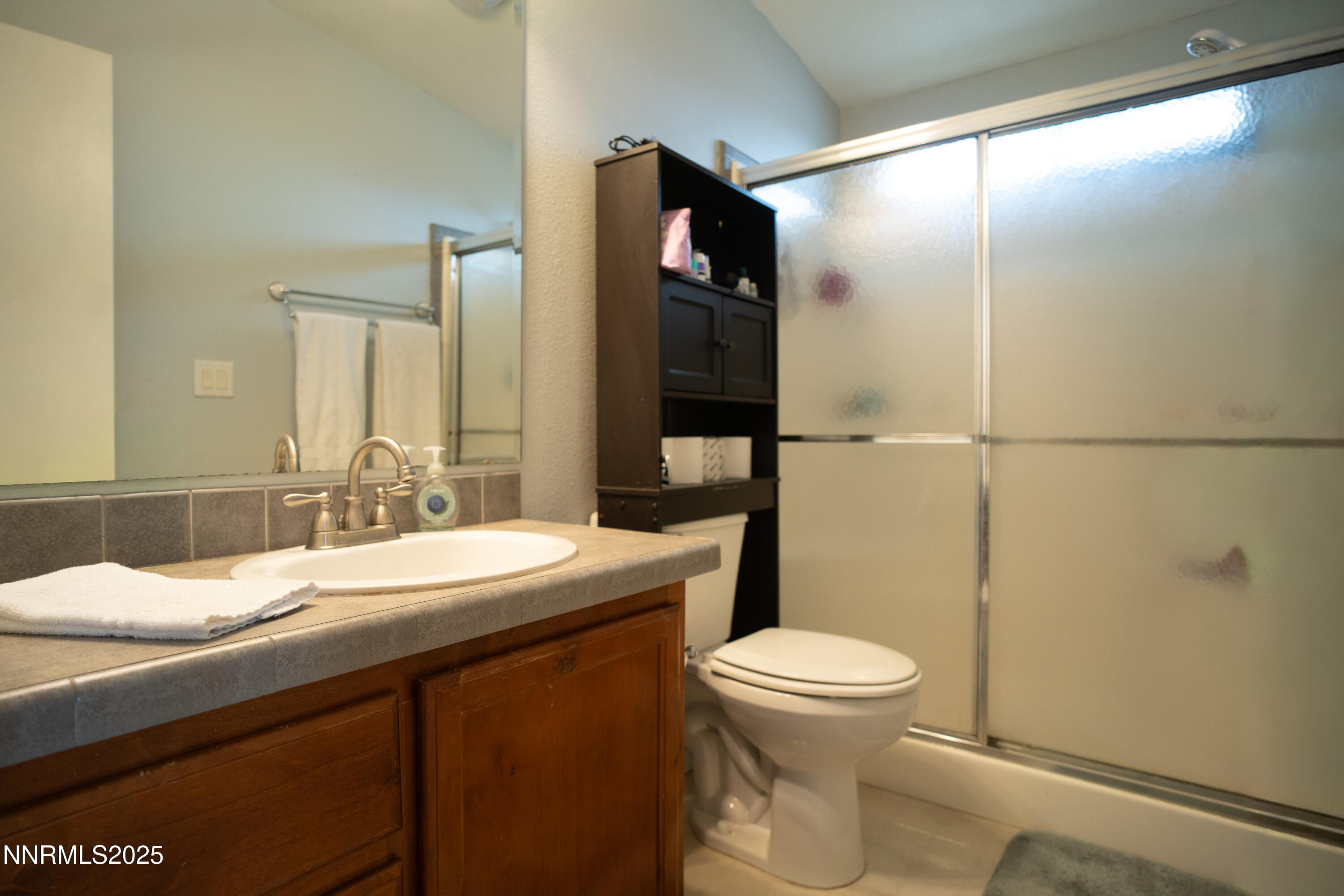 3250 4th Street Silver Springs, NV 89429 - Photo 27 of 73 a bathroom with a sink a toilet a mirror and shower