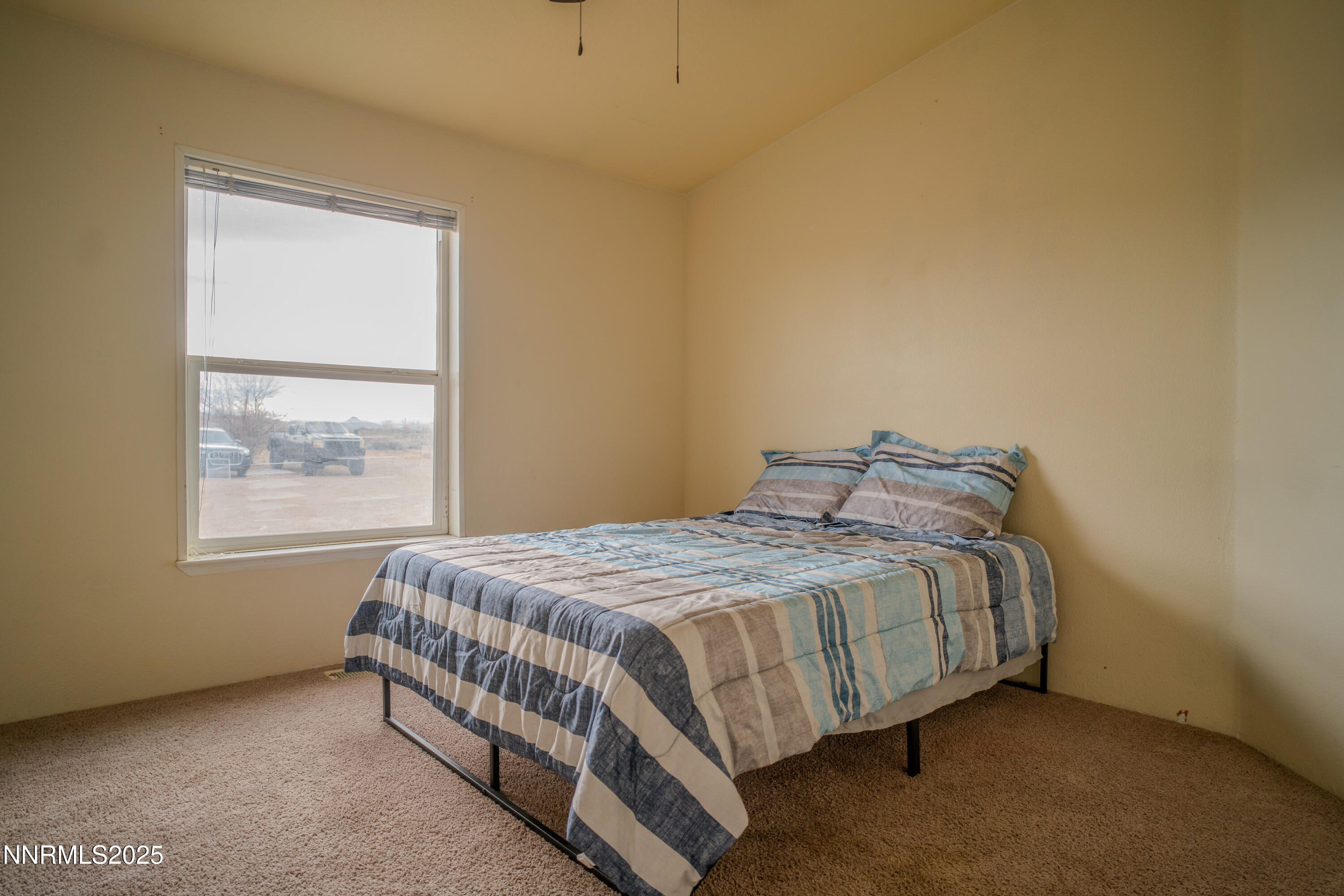 3250 4th Street Silver Springs, NV 89429 - Photo 36 of 73 a bed sitting in a bedroom next to a window