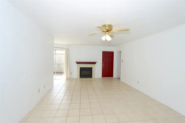 an empty room with a window and a fan