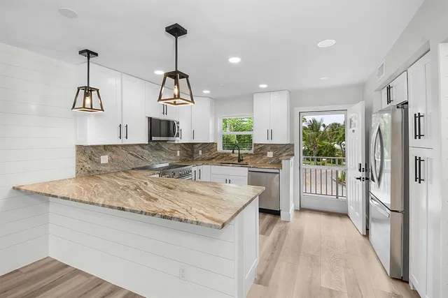 a kitchen with kitchen island granite countertop a stove and a sink