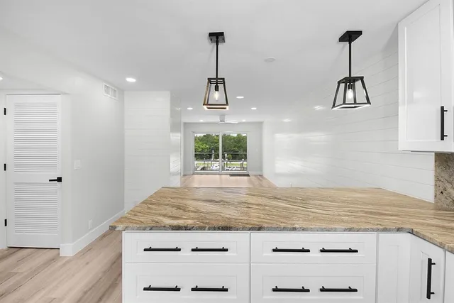 a kitchen with kitchen island a counter top space appliances and a window