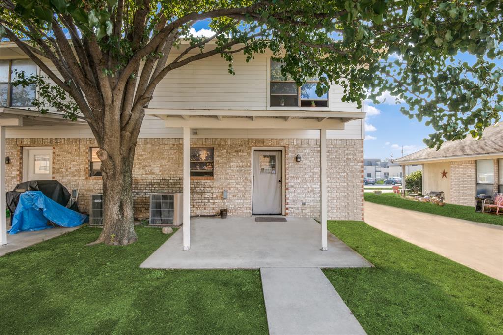 a front view of a house with a yard and trees