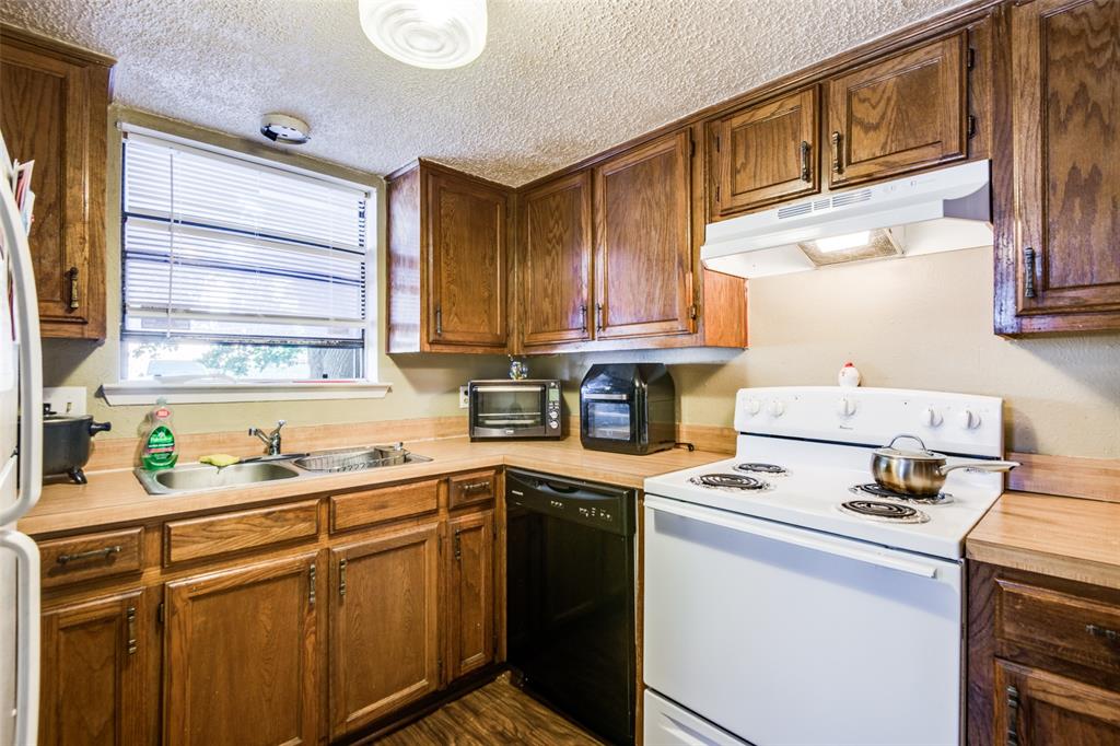 3309 Fallmeadow Street Denton, TX 76207 - Photo 7 of 12 a kitchen with stainless steel appliances a sink stove and cabinets