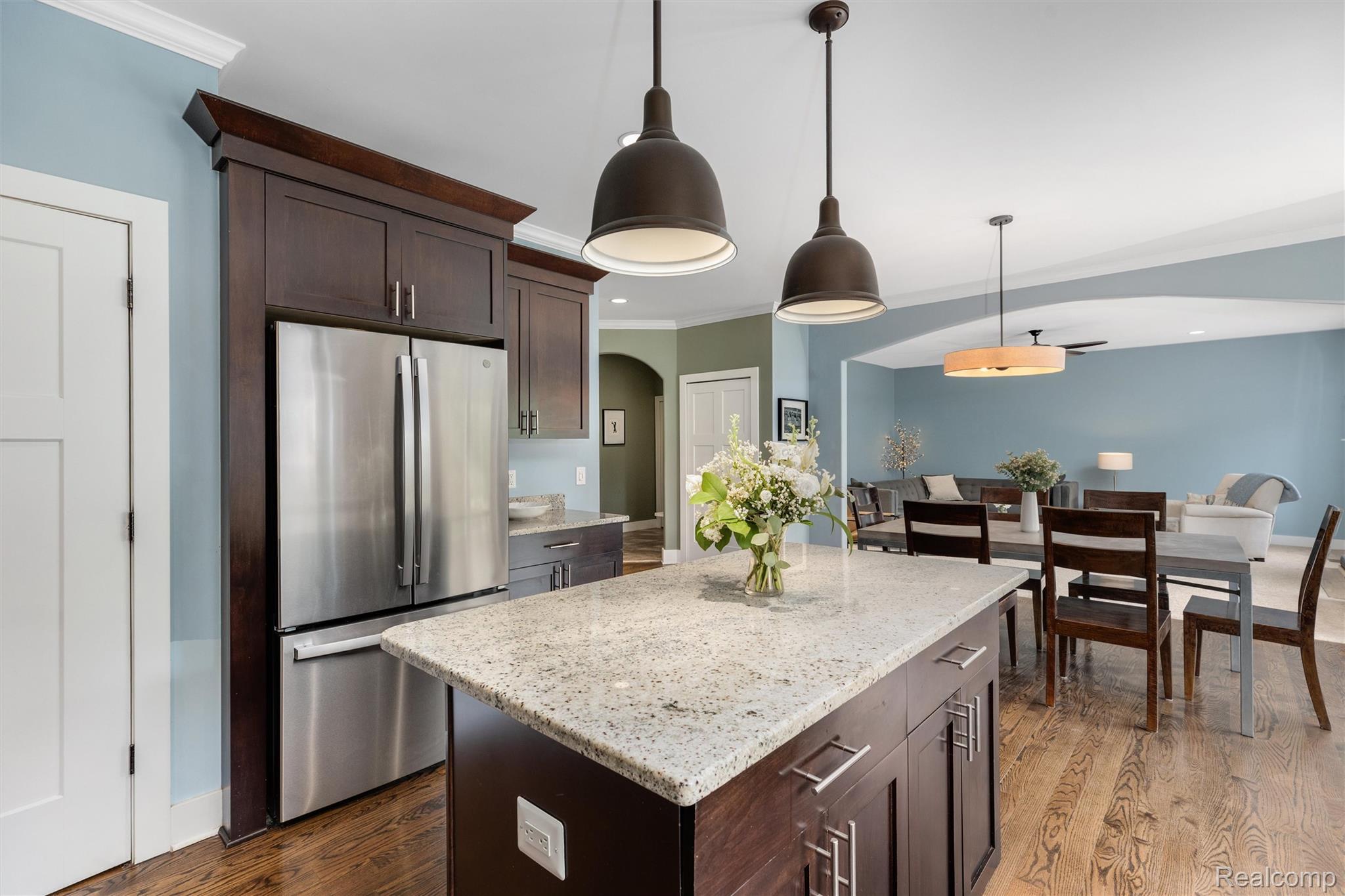 1016 West Snell Road Rochester, MI 48306 - Photo 15 of 35 Kitchen island with granite countertop, dark wood-finish cabinetry, and industrial-style pendant lighting