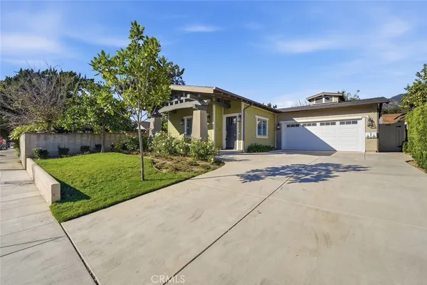 a front view of a house with a yard and trees
