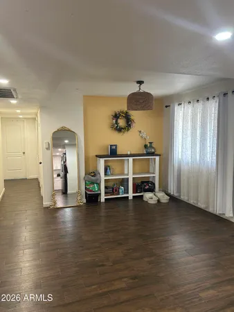 a view of a room with wooden floor water view and windows