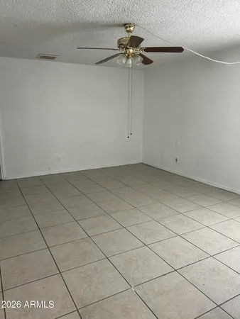 a view of an empty room and a chandelier fan