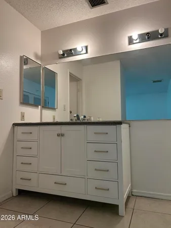 a bathroom with a sink vanity and mirror