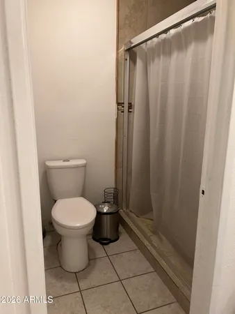 a bathroom with a toilet and a shower curtain
