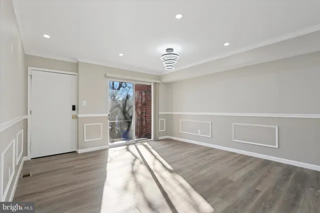 a view of empty room with wooden floor