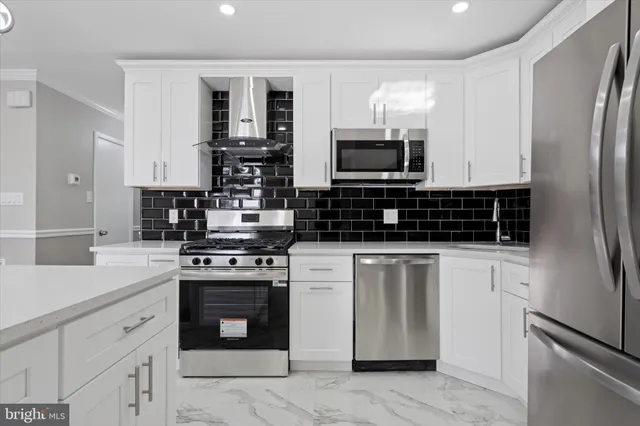 a kitchen with stainless steel appliances granite countertop a stove refrigerator sink and microwave