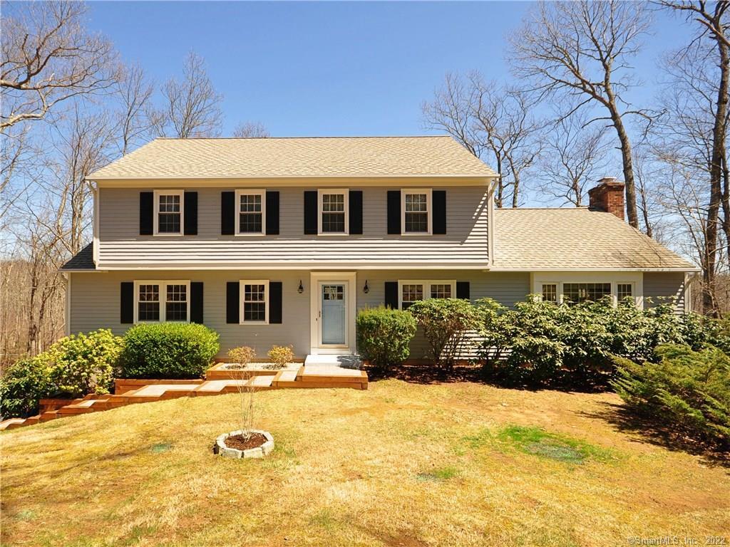 a front view of a house with yard and swimming pool