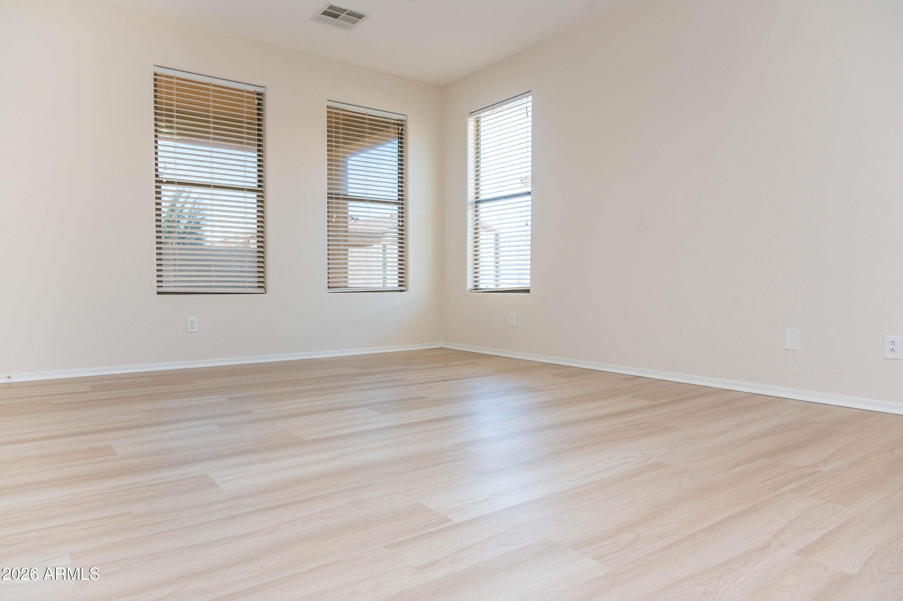 45633 West Mountain View Road Maricopa, AZ 85139 - Photo 14 of 78 an empty room with wooden floor and windows