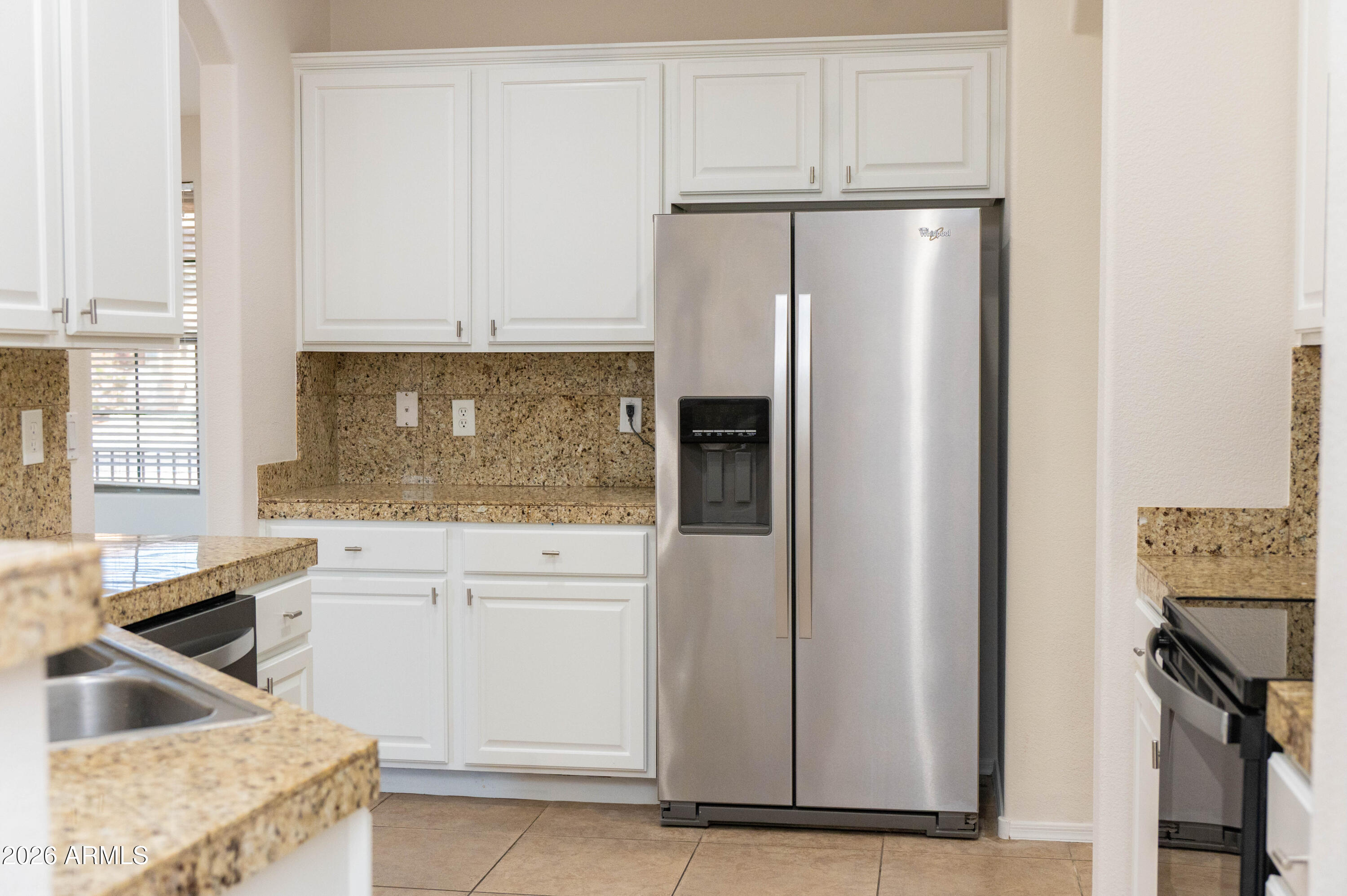 45633 West Mountain View Road Maricopa, AZ 85139 - Photo 24 of 78 a kitchen with a refrigerator sink and cabinets