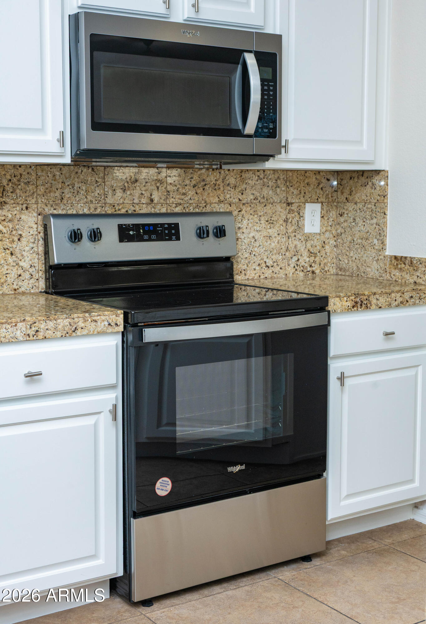 45633 West Mountain View Road Maricopa, AZ 85139 - Photo 26 of 78 a kitchen with granite countertop white cabinets and black appliances