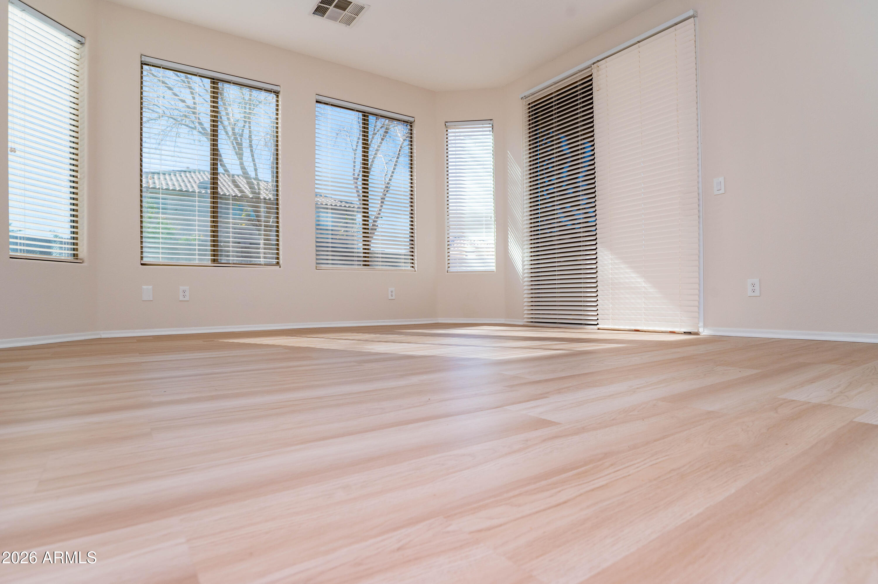 45633 West Mountain View Road Maricopa, AZ 85139 - Photo 33 of 78 a view of empty room with wooden floor and fan