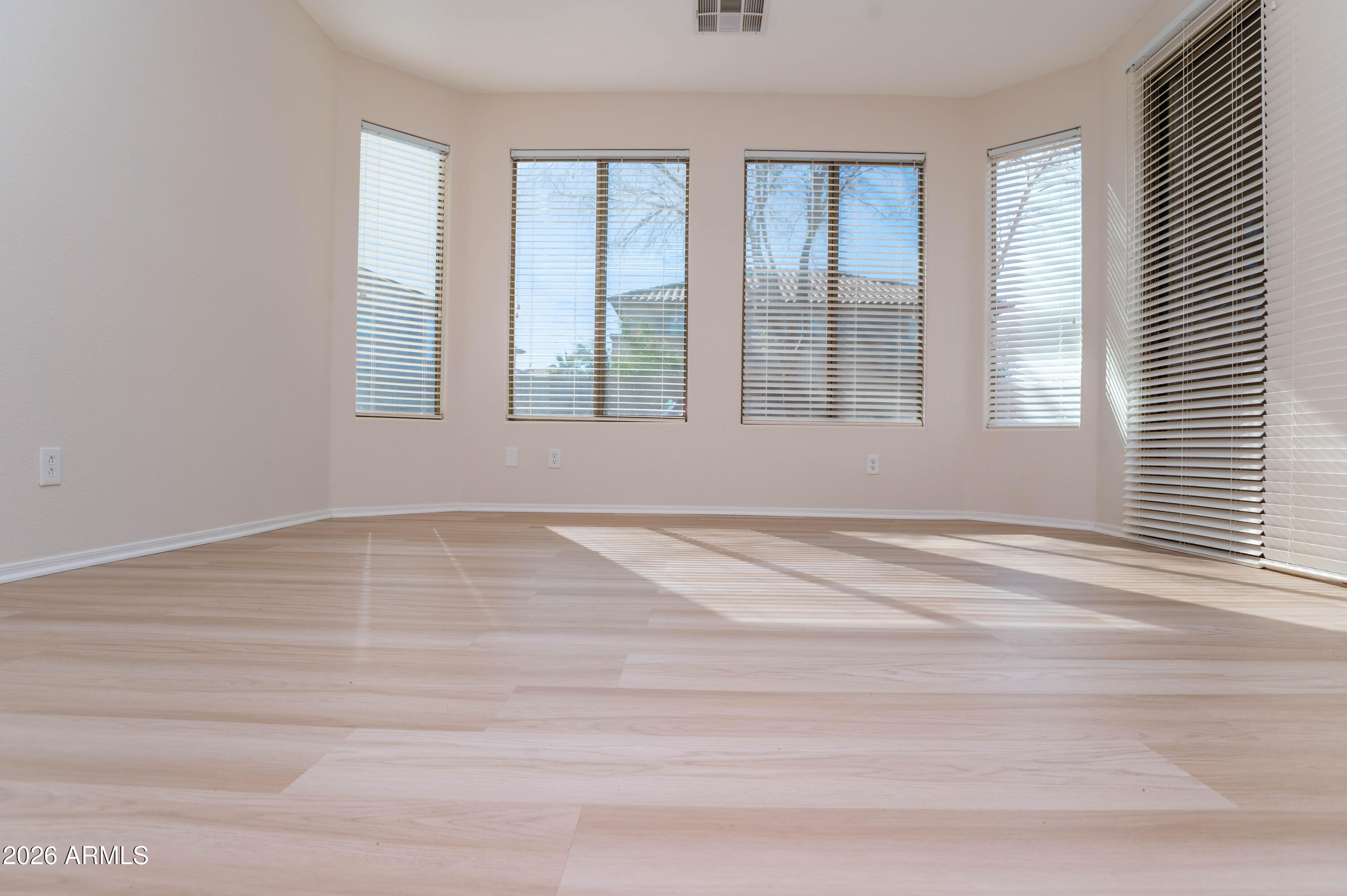 45633 West Mountain View Road Maricopa, AZ 85139 - Photo 34 of 78 a view of an empty room with wooden floor and a window