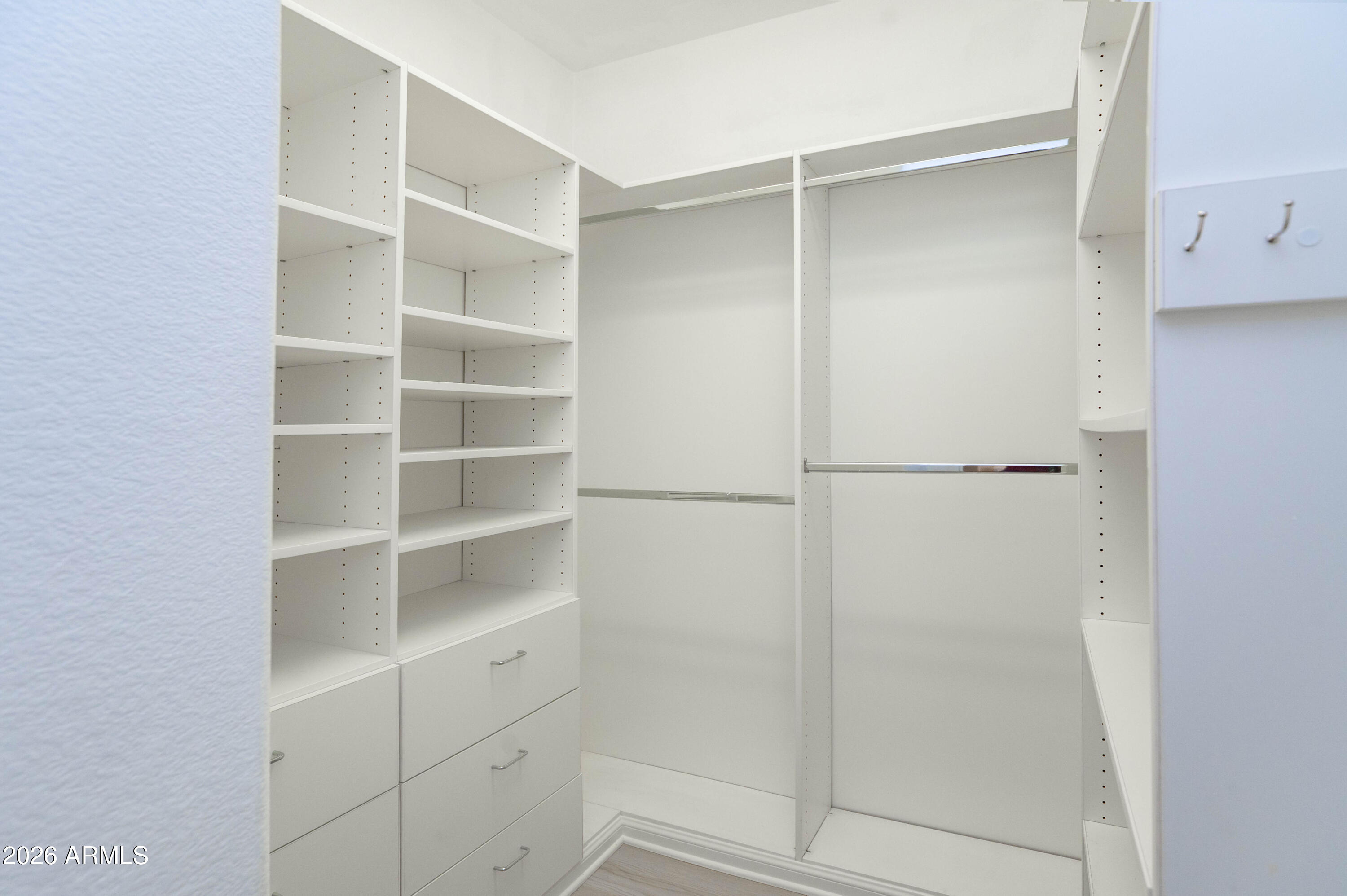 45633 West Mountain View Road Maricopa, AZ 85139 - Photo 35 of 78 a view of walk in closet with empty racks