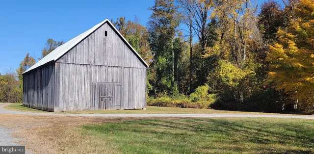 a view of backyard of house with wooden fence