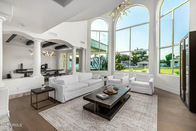 a bedroom with a bed a chandelier and a flat screen tv