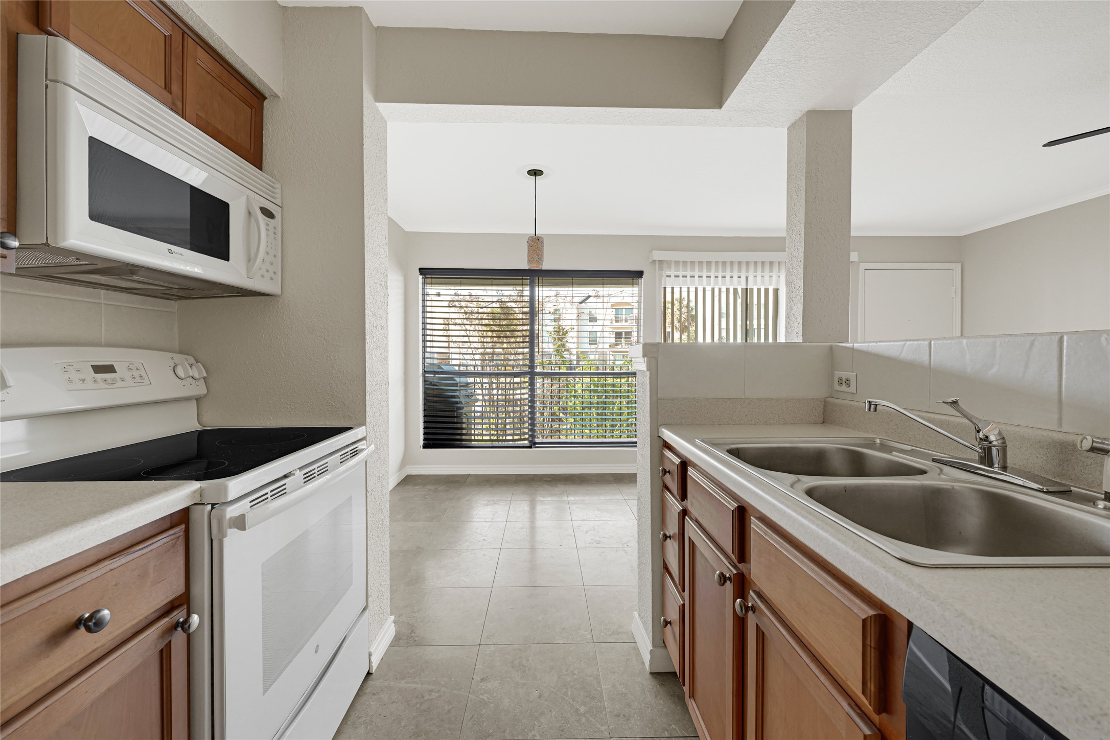 4011 NASA Road 1, Unit 406 El Lago, TX 77586 - Photo 12 of 23 a kitchen that has a sink a stove and microwave