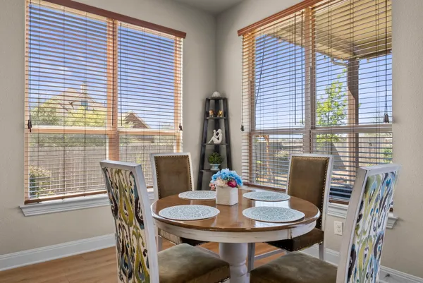 a bedroom with a bed potted plant on the dresser and a wooden floor