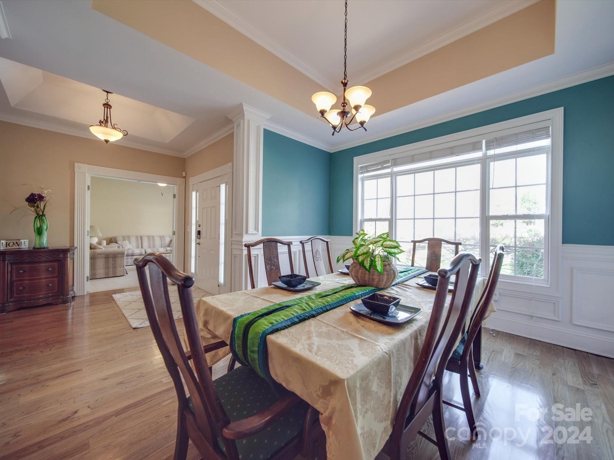 19617 Coachmans Trace Cornelius, NC 28031 - Photo 17 of 46 a view of a dining room with furniture a chandelier and wooden floor