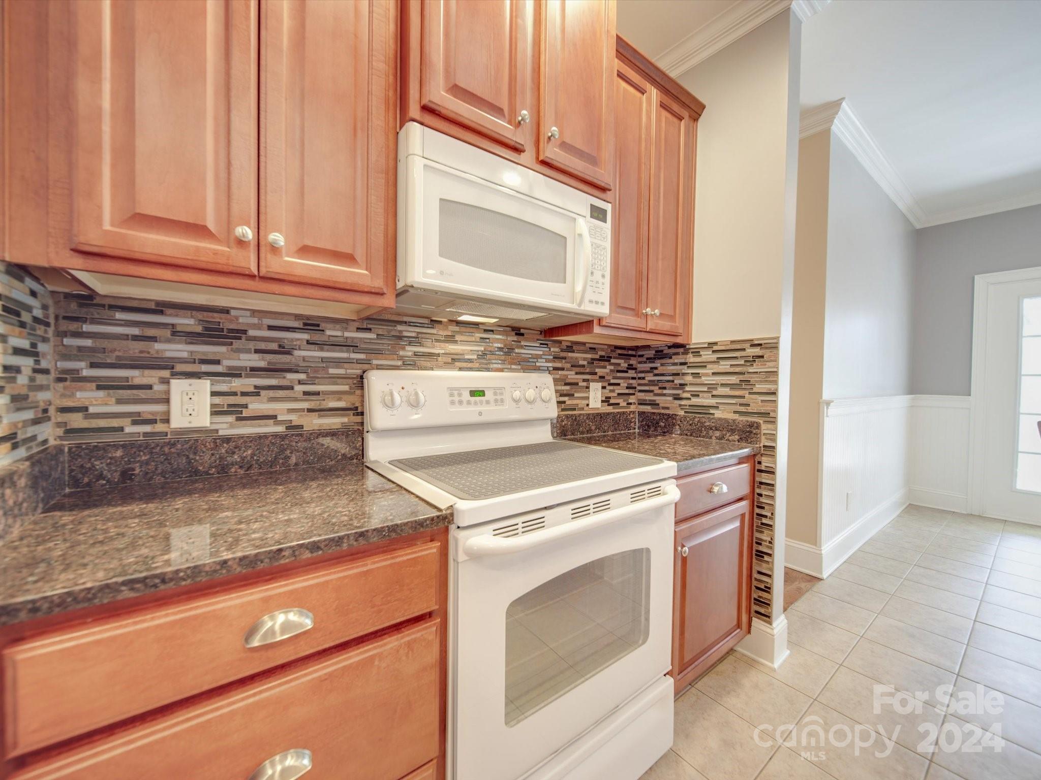 19617 Coachmans Trace Cornelius, NC 28031 - Photo 20 of 46 a kitchen with granite countertop a stove top oven microwave and cabinets