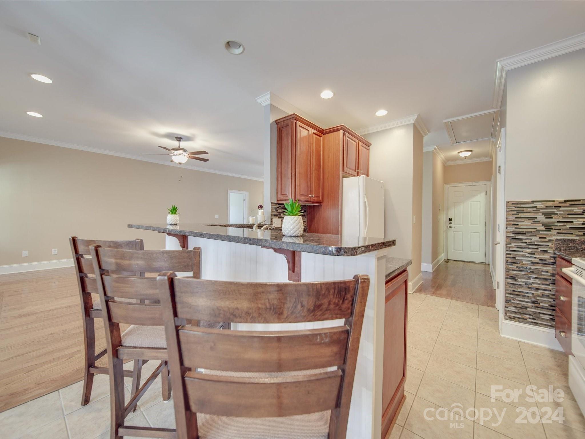 19617 Coachmans Trace Cornelius, NC 28031 - Photo 23 of 46 a dining hall with stainless steel appliances kitchen island granite countertop a dining table and chairs