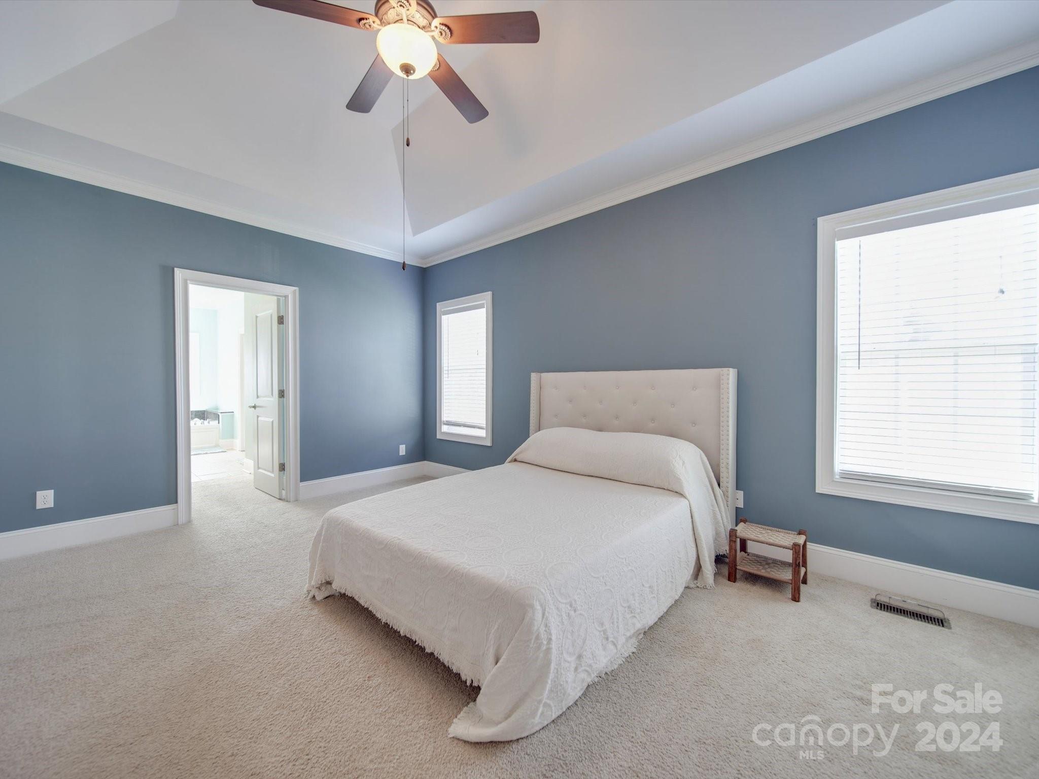 19617 Coachmans Trace Cornelius, NC 28031 - Photo 5 of 46 a spacious bedroom with a bed and a chandelier