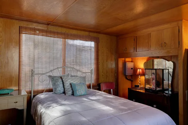 a bedroom with a bed and wooden floor