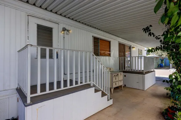 a view of a house with a small yard and wooden fence