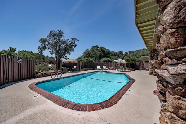 a view of a swimming pool with a yard and seating area