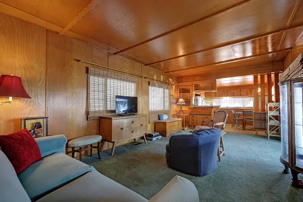 a living room with furniture a flat screen tv and windows