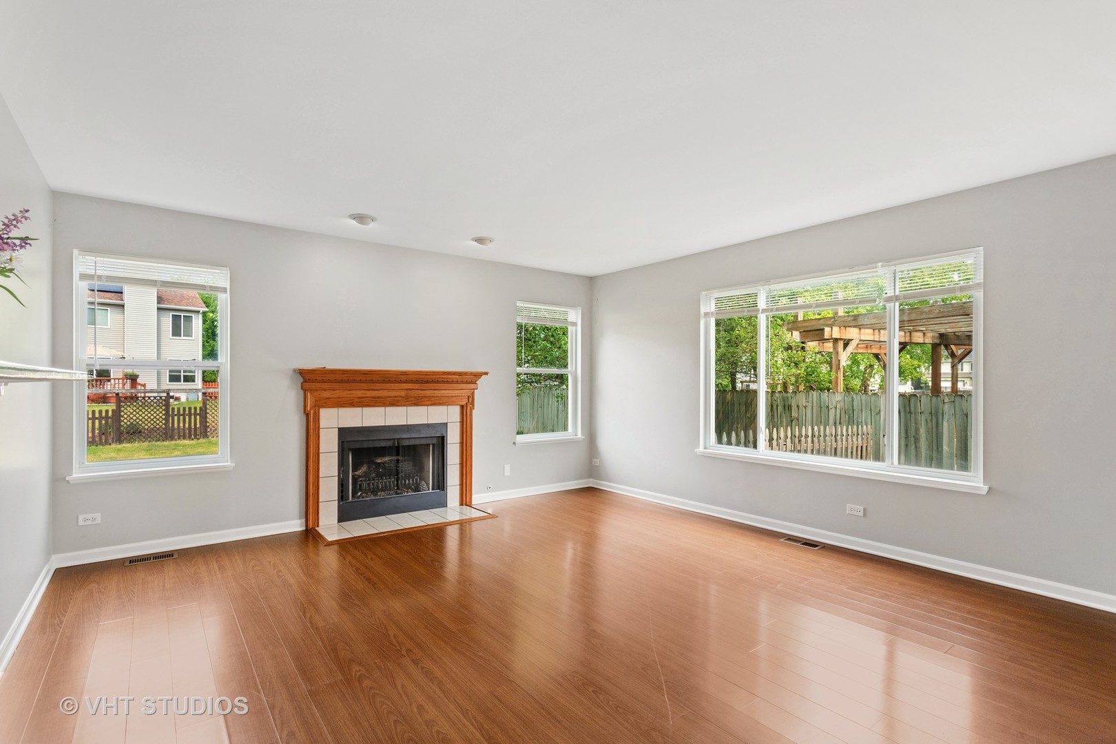823 Fieldcrest Drive Naperville, IL 60540 - Photo 9 of 30 an empty room with windows a fireplace and wooden floor